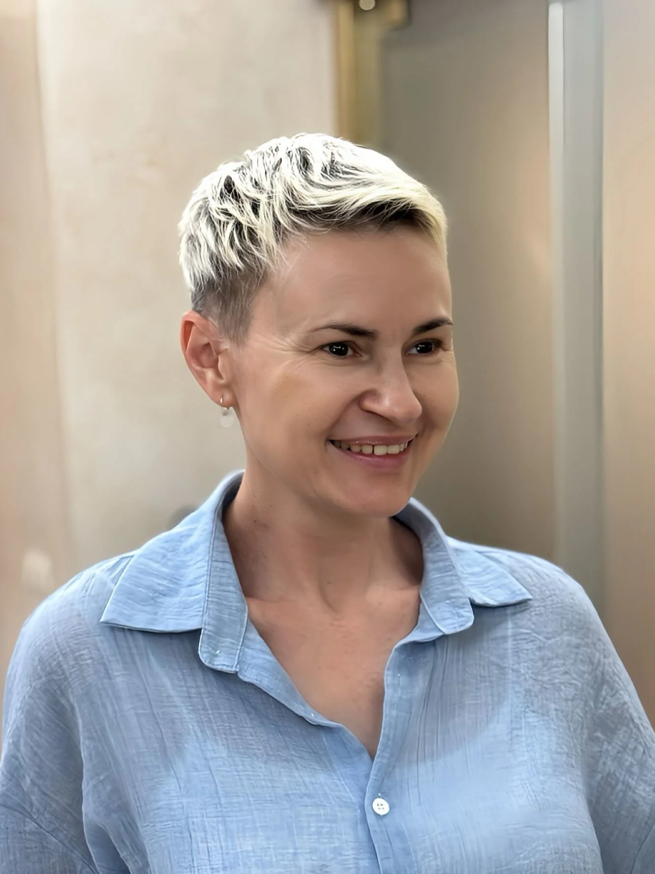 Blonde textured pixie with darker roots and tapered sides