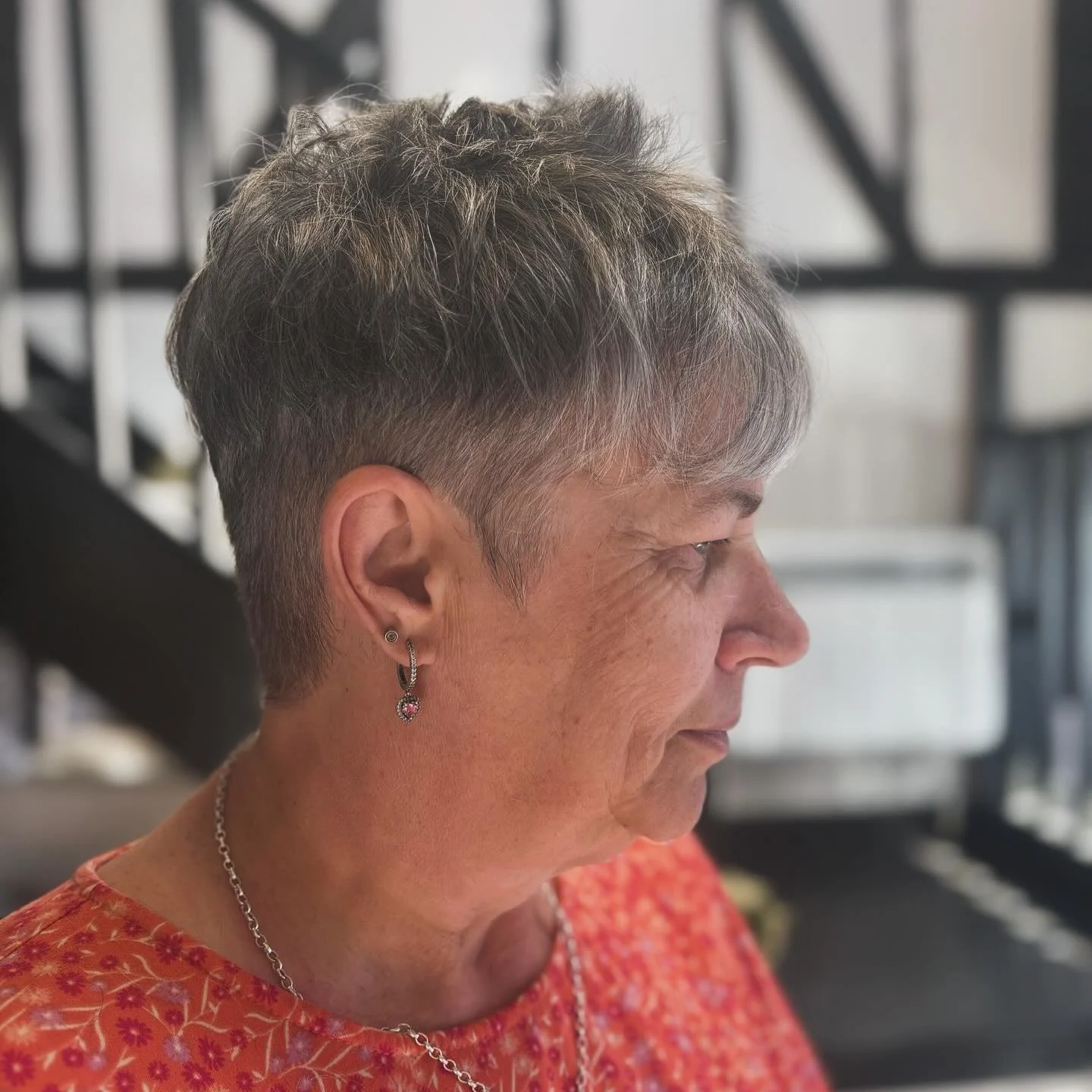 Tousled layered pixie with side leaning fringe and grey tones